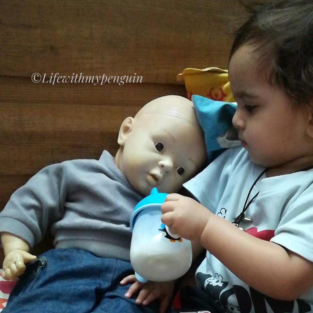 toddler boy playing with doll