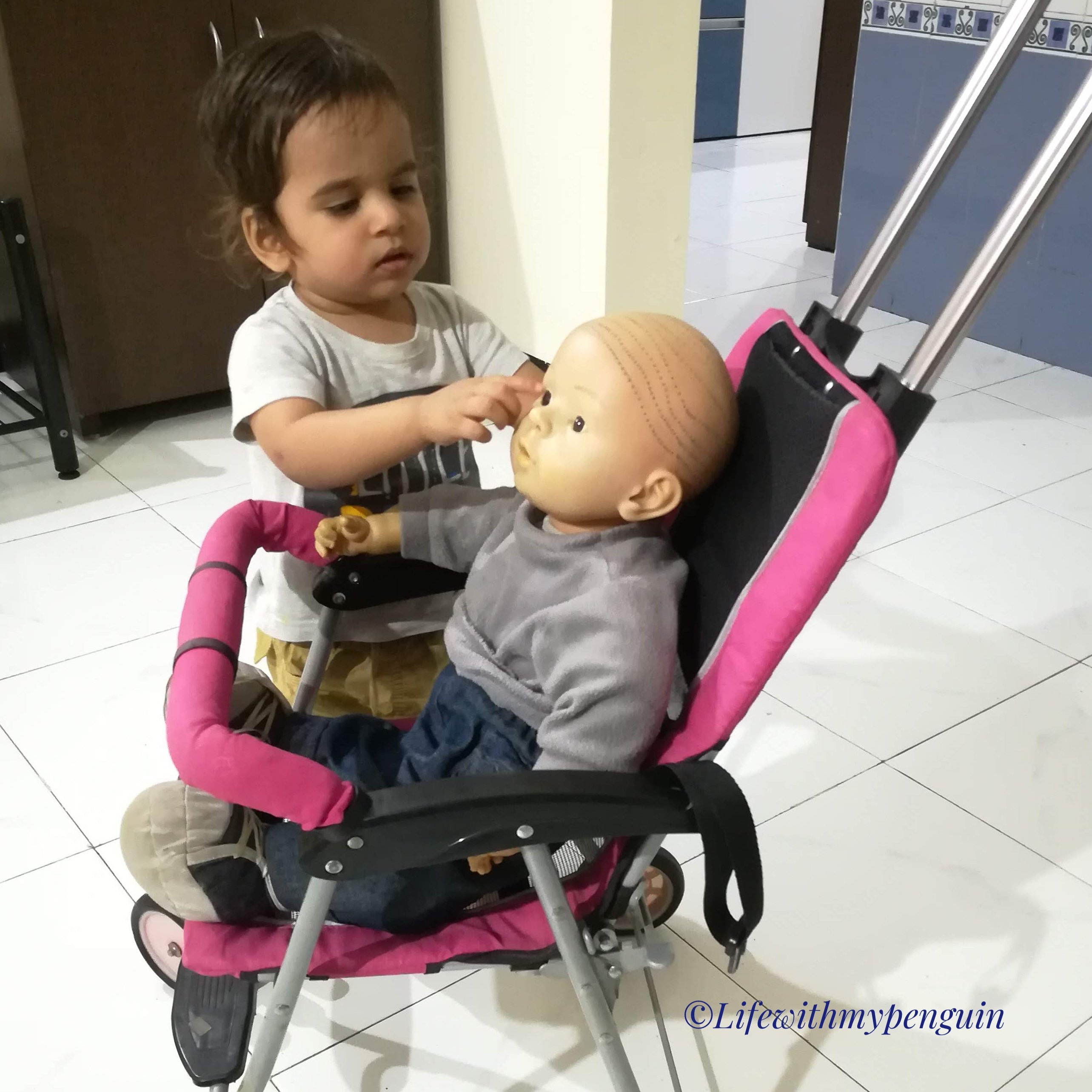 toddler boy plays with doll